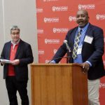 A Hastie Fellow speaks at a podium.