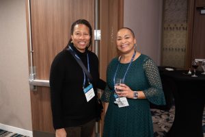 Event participants, both women of color, smiling to the camera.