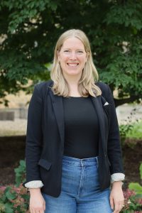 Photo of Emily Buchholz, a woman with fair skin, blond hair, and blue eyes.