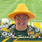 Photo of man in Packers memorabilia, sunglasses, and a cheese hat.