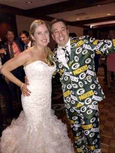 Marie Packer in a white wedding dress with her husband, Ryan in a Packers themed suit.