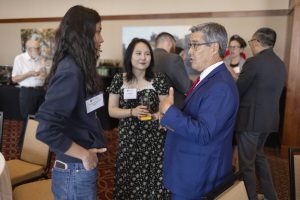 Two women with dark hair speak with the Law School Dean Dan Tokaji who is gesturing as he speaks.