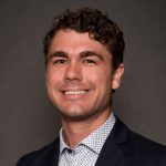 Photo of Charlie, a young man with curly brown hair and a gentle smile
