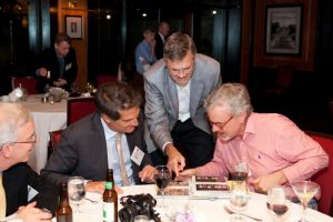 3 alumni gathered together at a table