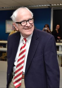 Photo of senior man in blue suit jacket and red/white striped tie.