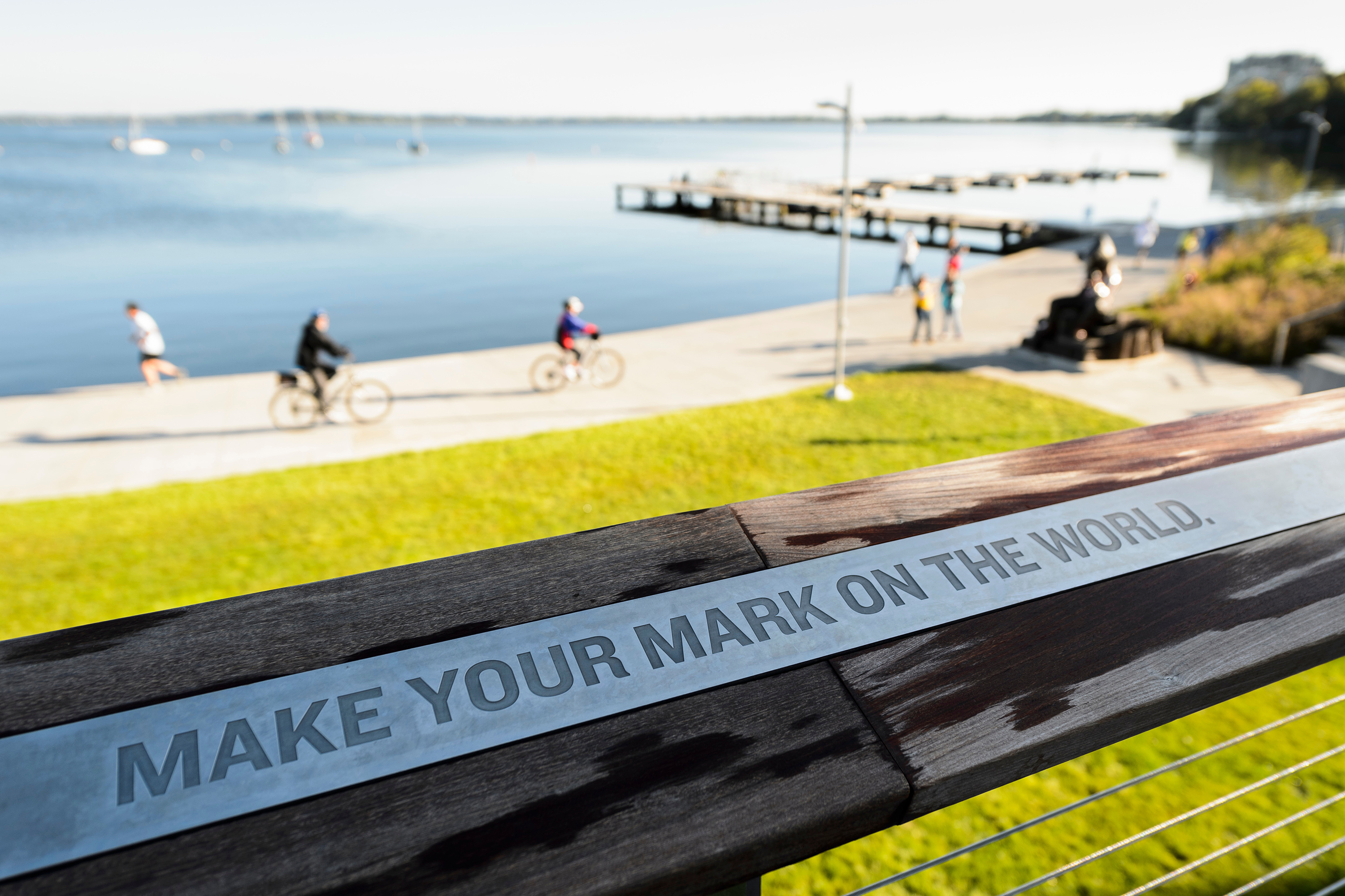 Sign at Alumni Park that says "Make your mark on the world"