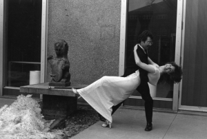male student dipping female student in front of gargoyle