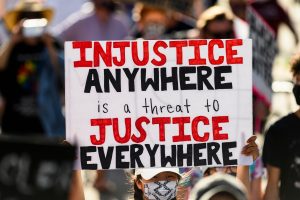 BLM march sign: "Injustice anywhere is a threat to justice everywhere"