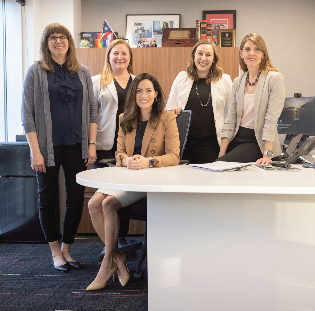 The five UW Law School Admissions staff smiling in their office.