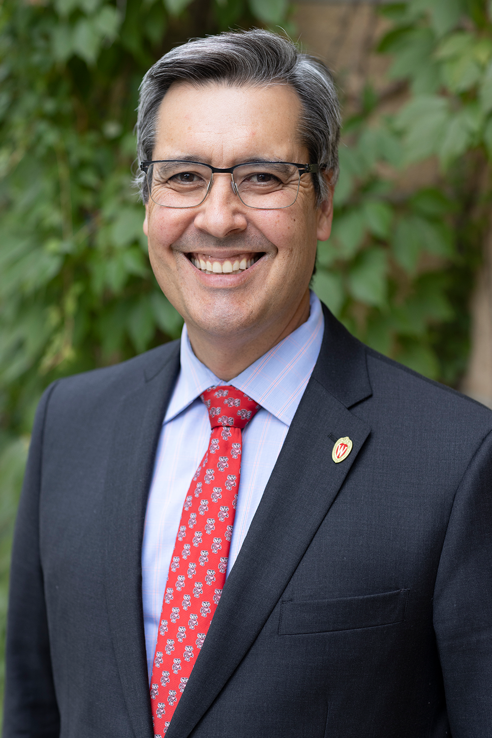 Photo of UW Law School Dean Daniel Tokaji, smiling and wearing a suit with a Bucky Badger tie