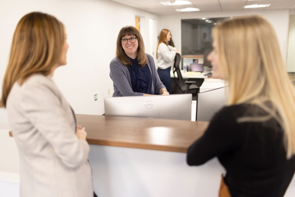 Women laugh in an office setting.