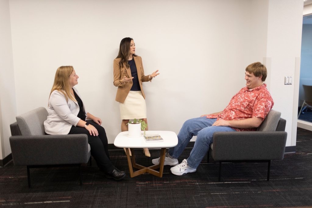 Two women speak to a male student.