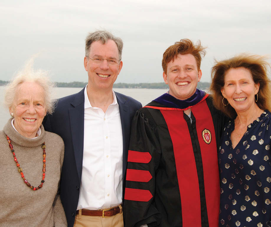 A family stands with a graduate on the shore of a Madison lake.