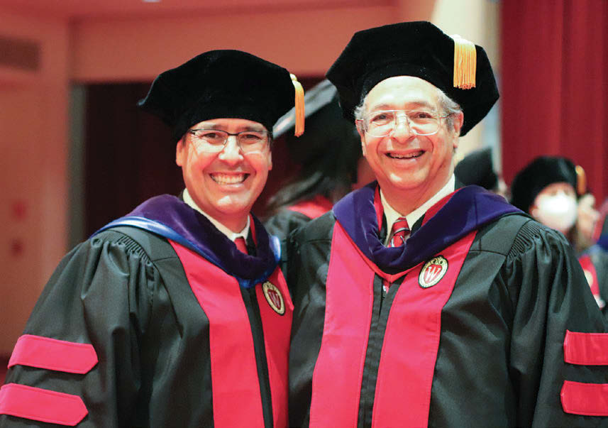 Two men smiling while wearing graduation garb: UW Law School Dean Dan Tokaji and special commencement speaker, Judge Louise Butler.