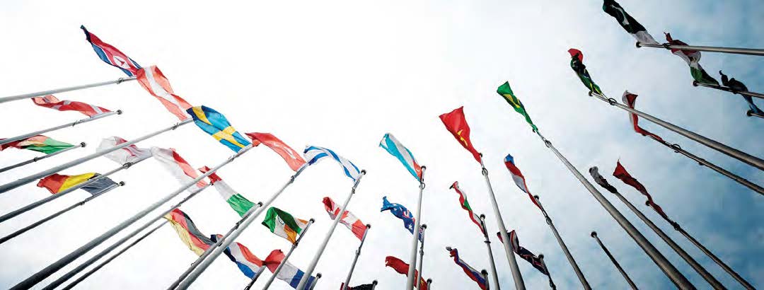 A view of multiple country flags from below.