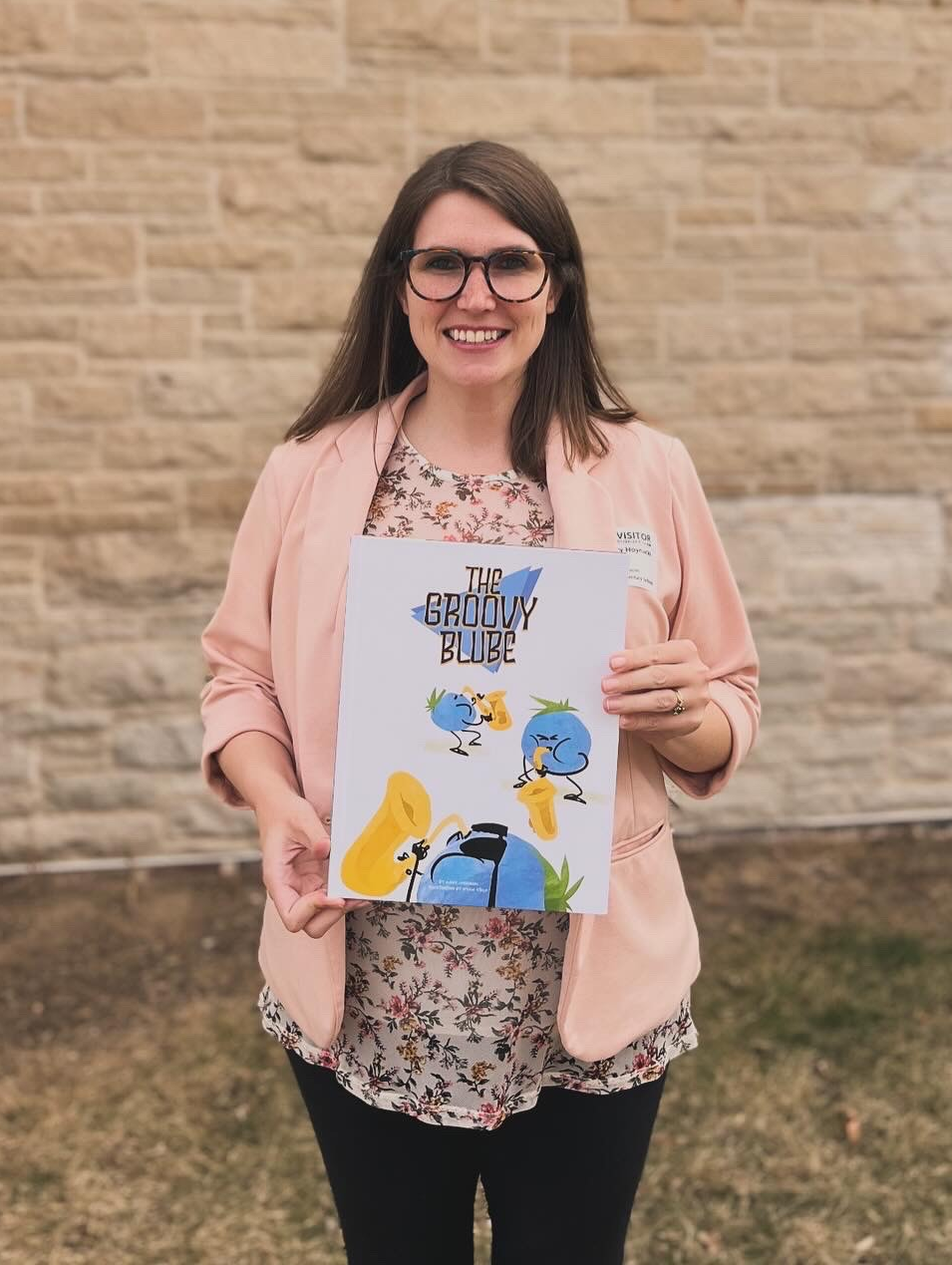 Headshot photo of Mary Hoynacki holding her children's book "The Groove Blube."
