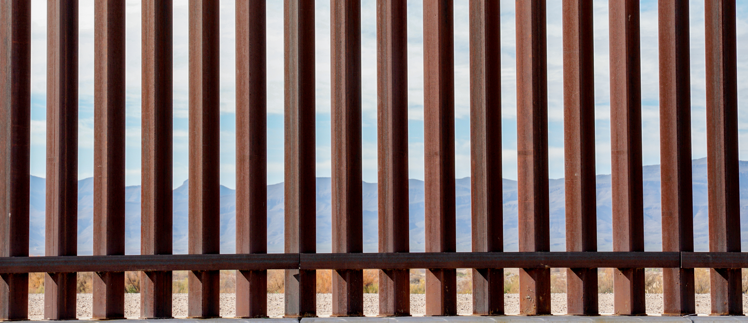 A photo of the metal border wall separating the US and Mexico.