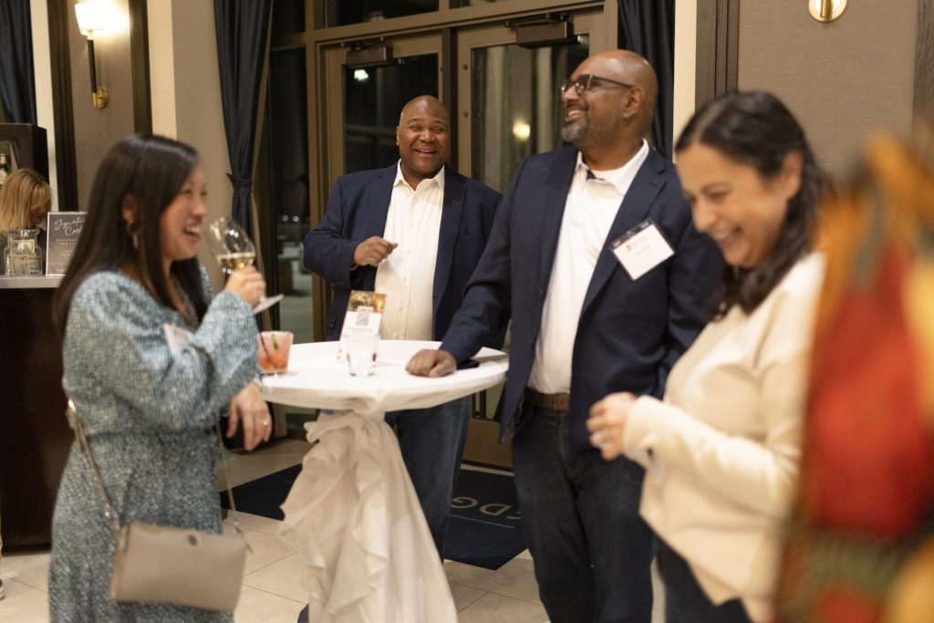 Several people of color are laughing together while at the reunion event.