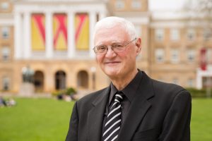 A photo of Don Downs standing on Bascom Hill with the Bascom Hall blurry in the background.