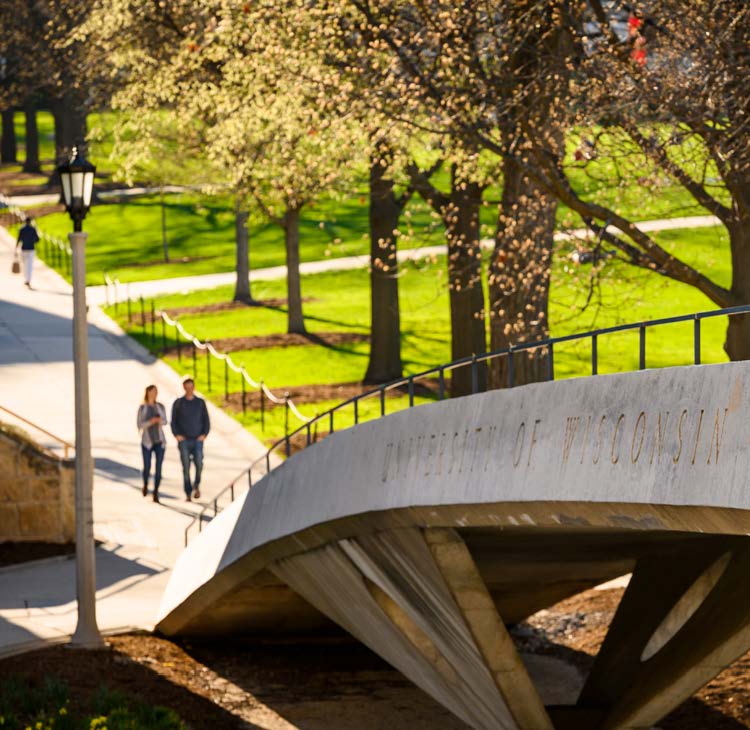 A photo looking across an arched pedestrian bridge that connects Bascom Hill area to another in downtown Madison, WI.