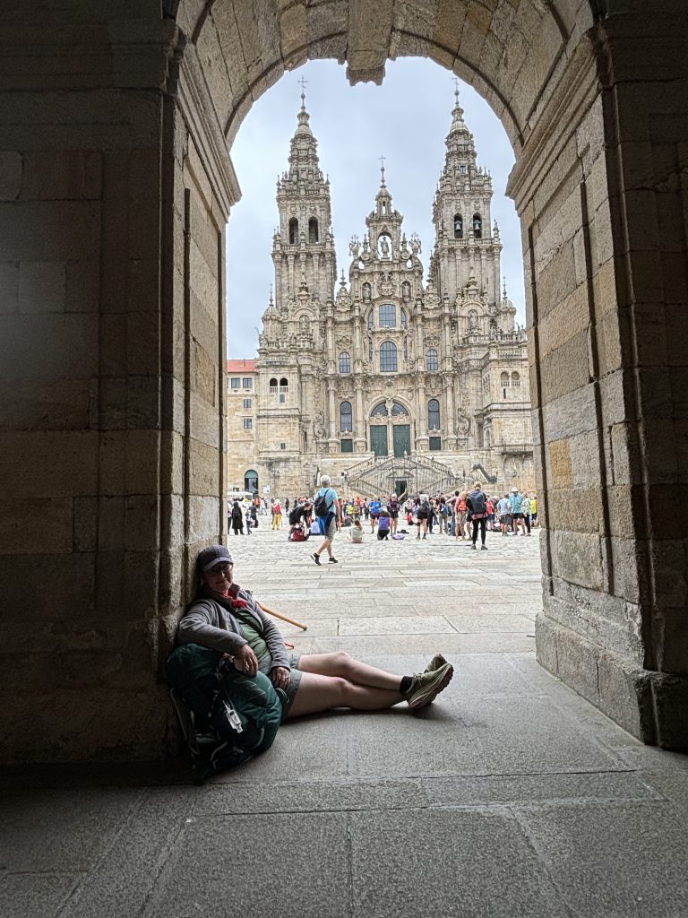 Sara Beachy Waters sitting in a stone archway in Spain.