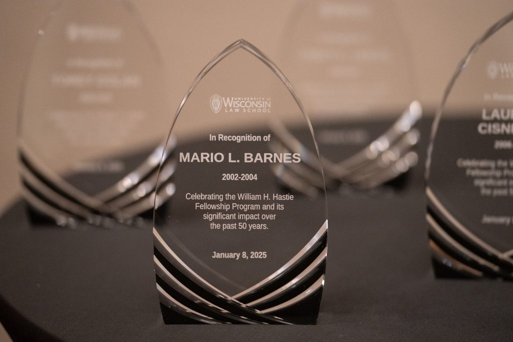 Photo of award closeup - a glass wedge in the shape of an arch with Mario L. Barnes etched onto it.