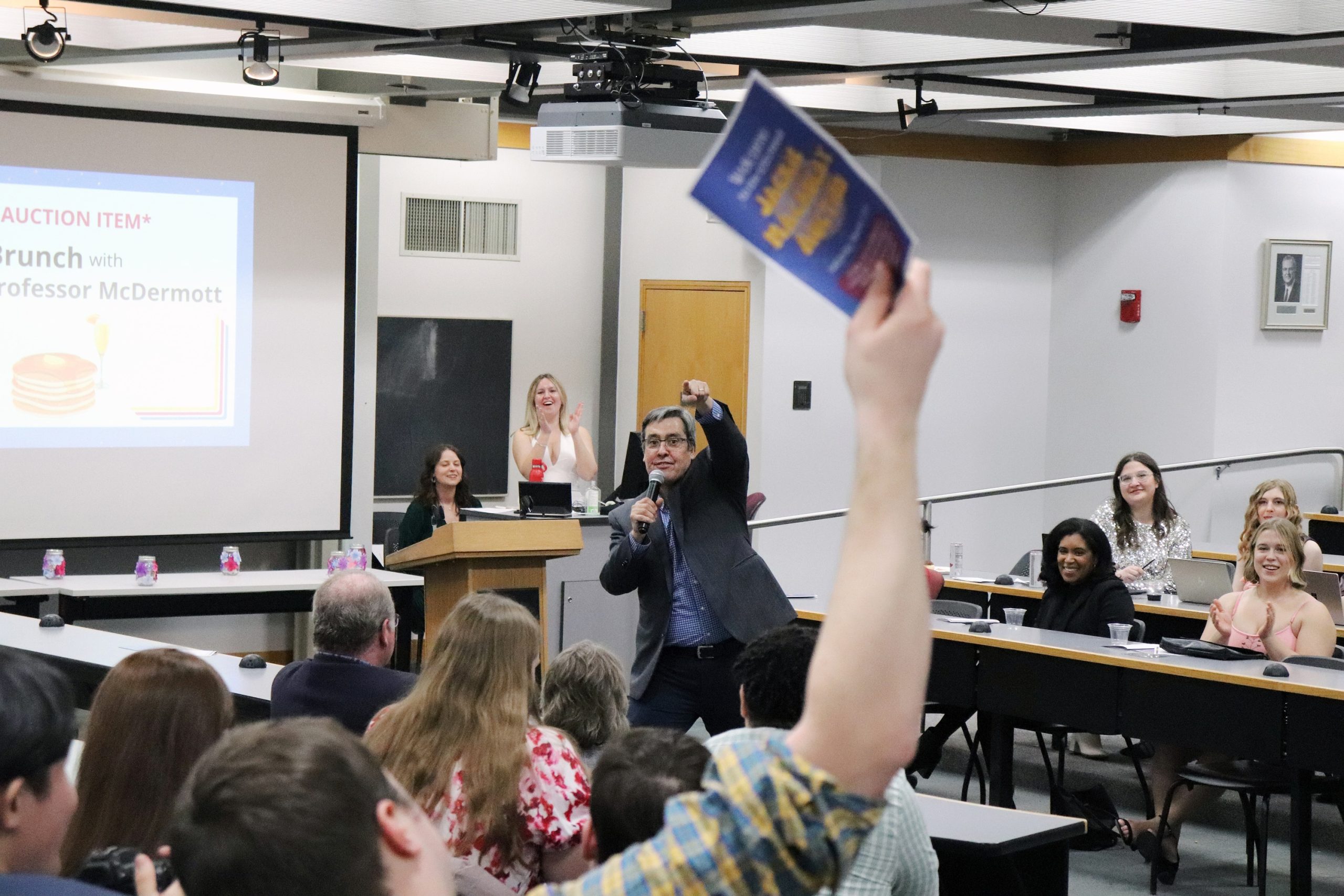 Dan Tokaji points to a bidder jubilantly during the Jackie Macaulay Auction.