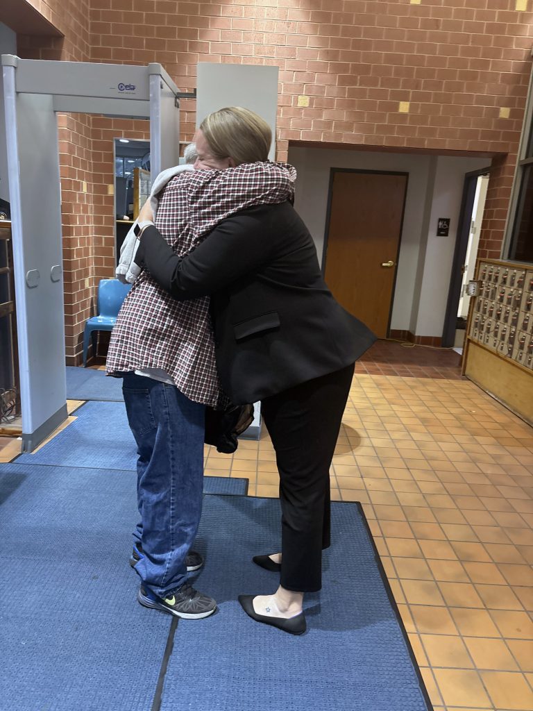David Bintz and Rachel Burg hug in the entryway.