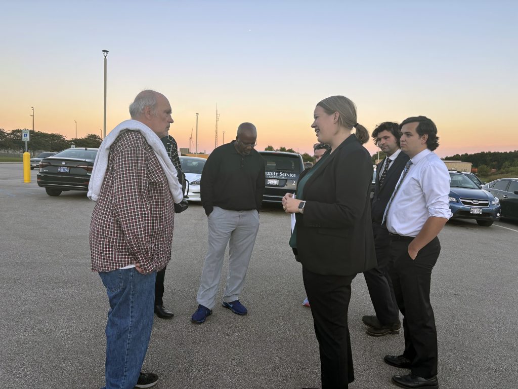 Rachel Burg speaks with David Bintz in the parking lot alongside several other people from the Wisconsin Innocence Project.