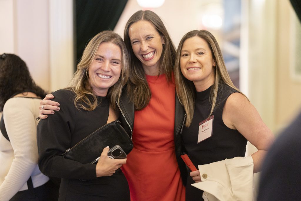 Three women stand together.
