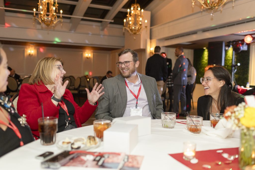 A woman gestures while speaking while two other people listen.
