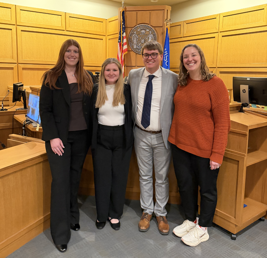 People stand in front of a judge's bench.