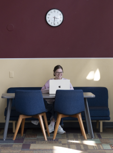 Student sits at a table in the Law School atrium.